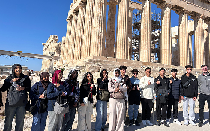 Group photo of students stood in front of the Acropolis of Athens in Greece