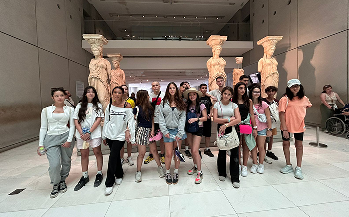 Students stood in front of a historical statue in a museum in Greece