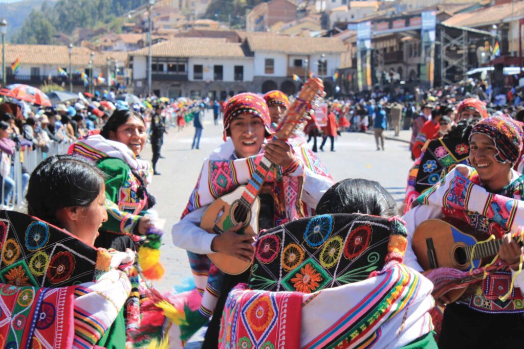 Local people dressed in traditional clothing playing instruments in the plaza in Peru