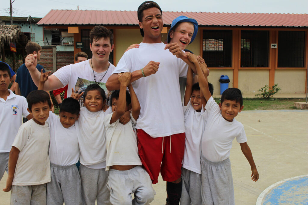 group of boy travellers playing games with local childrens in costa rica