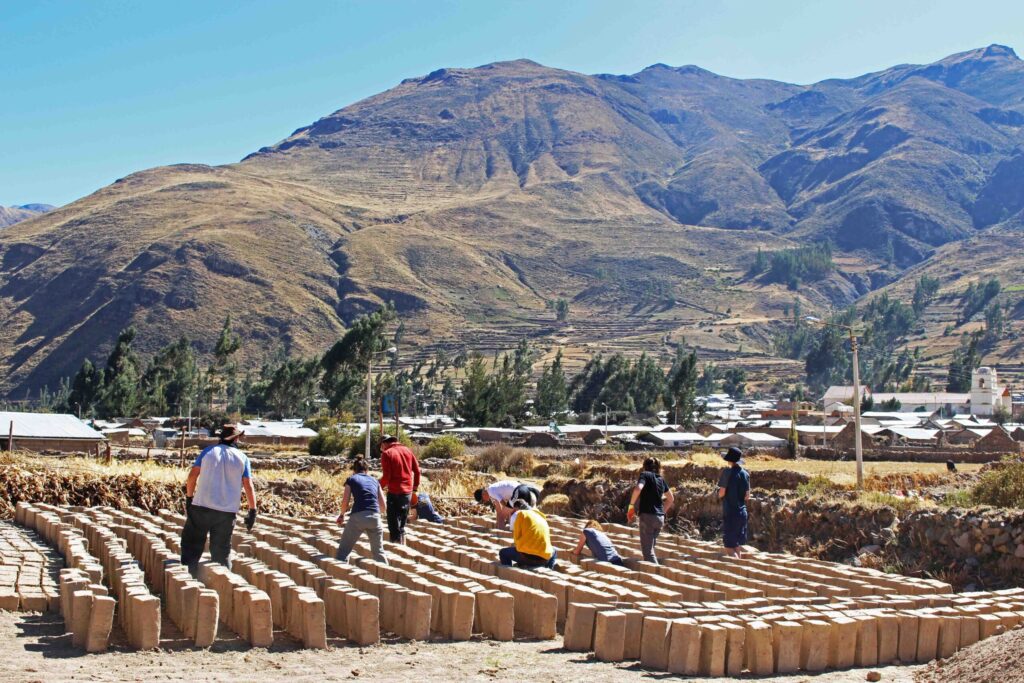 Student travellers working on a project in Peru laying bricks