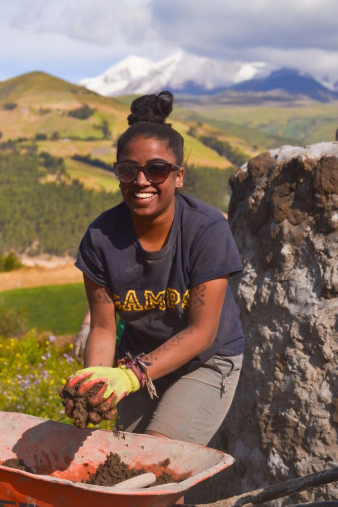 Traveller student working on a project in Ecuador with a view of the mountains behind her