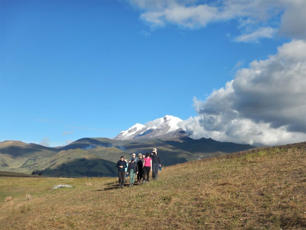 Student travellers walking in a field near volcano Cayambe in Ecuador