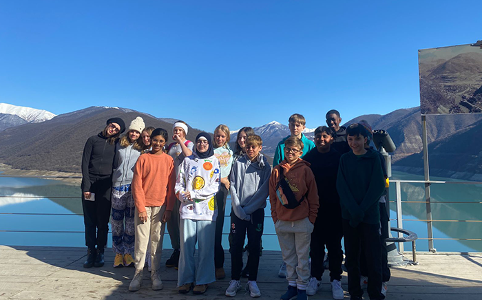Students taking a group photo in front of the Zhinvali Reservoir in Georgia