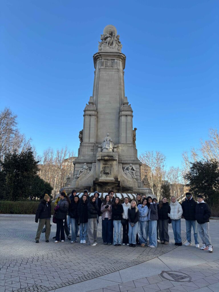 A group of student travellers standing in front of a statue in Madrid