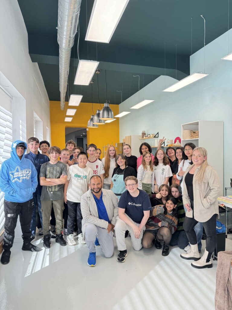 A group of young students with their teacher inside a modern kitchen.