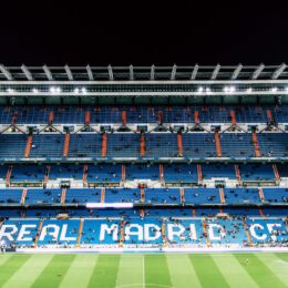 Real Madrid stadium in Spain with blue seats and grass football pitch