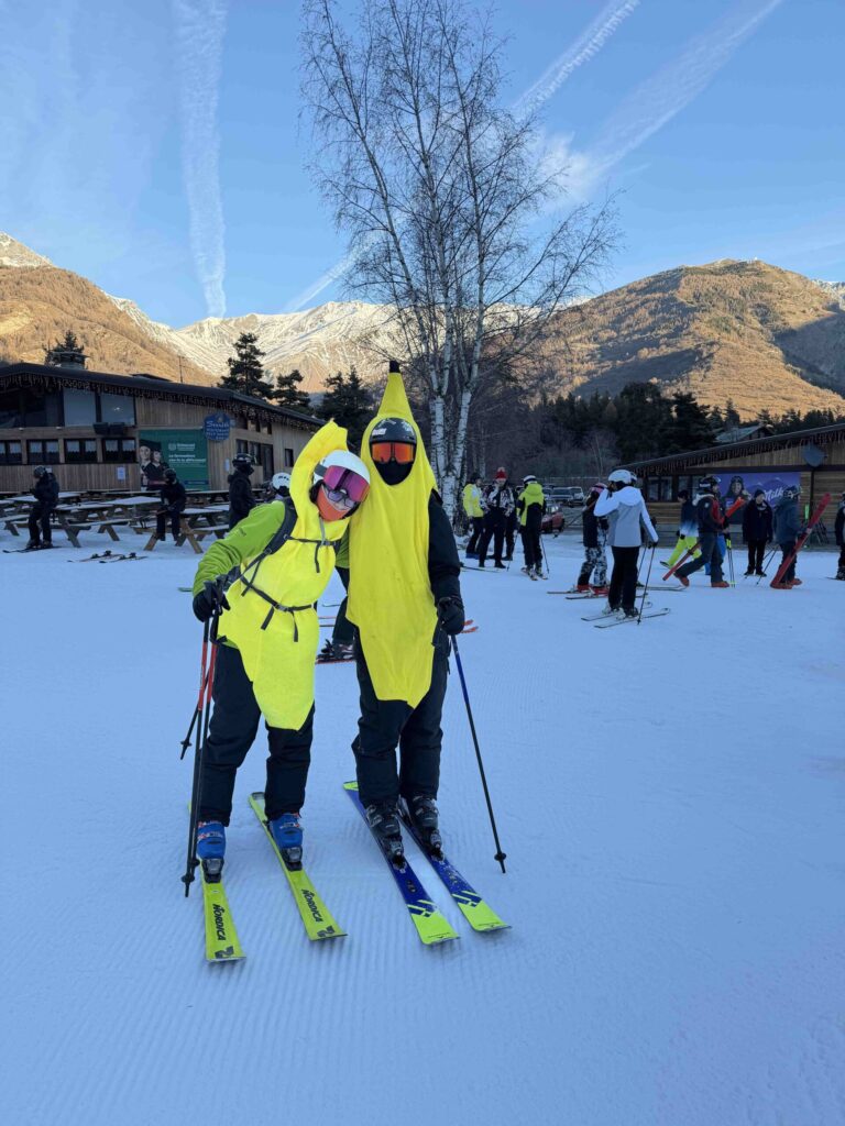 Two skiers playfully wearing funny banana costumes.