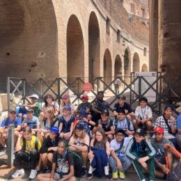 Group of students and teachers in the side of the Colosseum.